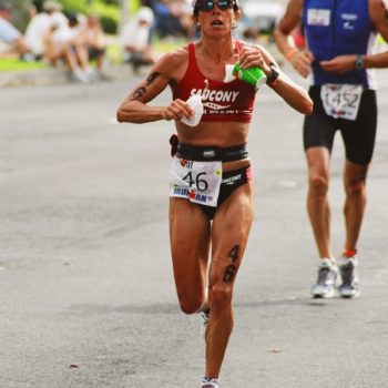 Female athlete running in a marathon race on a city street.