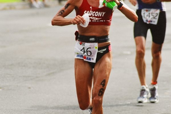 Female athlete running in a marathon race on a city street.