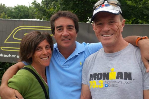 Three friends smiling and posing outdoors in casual clothes.
