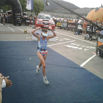 Female runner crossing the finish line in a race.