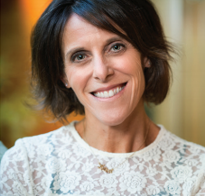 Smiling woman with short dark hair in a white lace top.